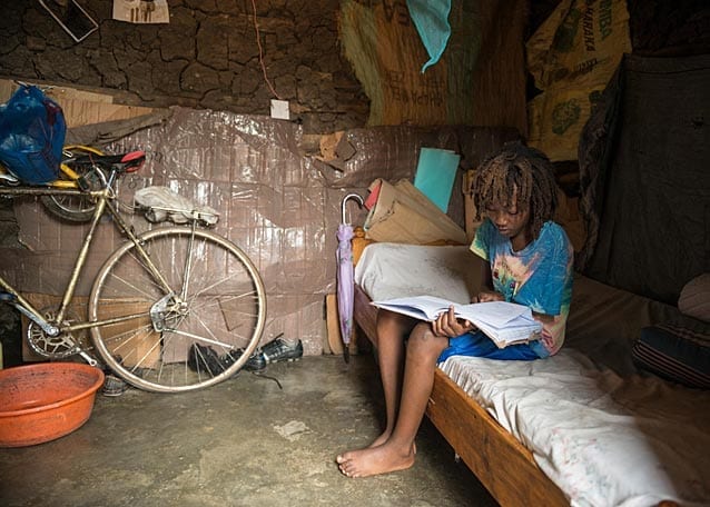 On Saturday Peter finds time to study on the single bed he shares with his two brothers.