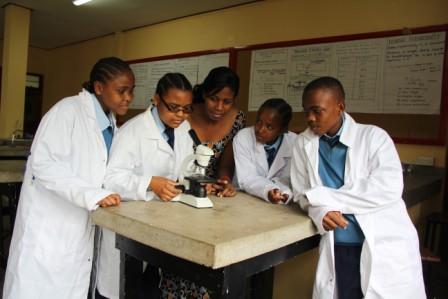 Biology teacher guides students in a science experiment