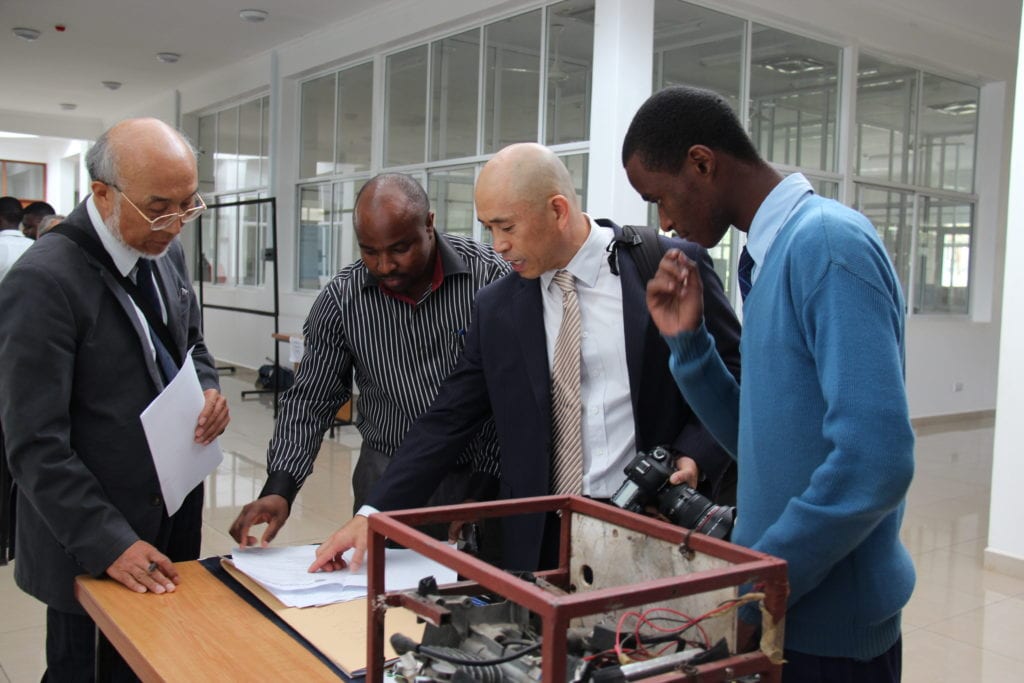 A St Jude student showing his project to NMI Professor Eugene Park, Head St Jude's Science Teacher Mr Mcharo and others at the fair.