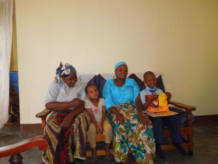 Lebahati proudly holding his books - he is with his family, in their home