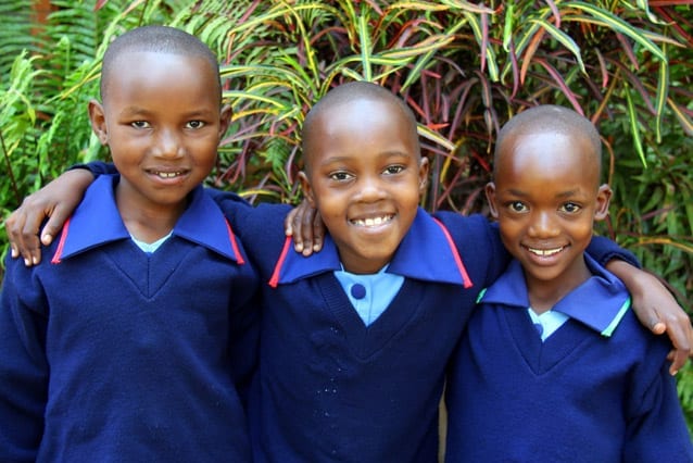 Happy environment: Asha (middle) has enjoyed making new friends like Rogathe (left) and Fatuma.