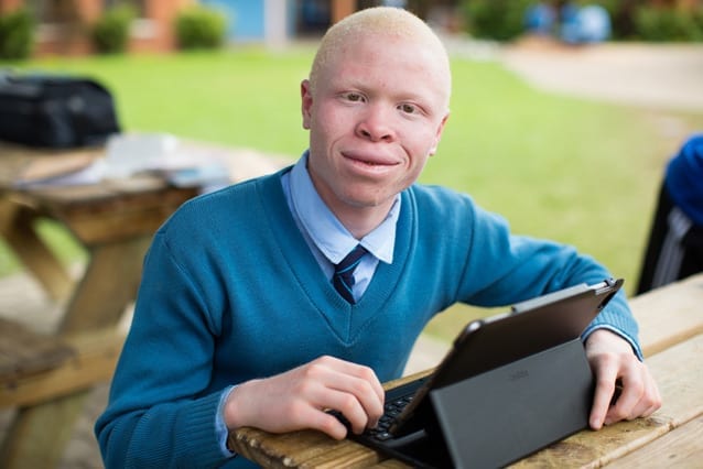 Reason to smile: Selemani can see the blackboard clearly using a camera and an iPad donated by St Jude's supporters.