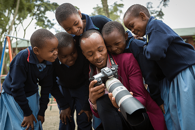 Crowd pleaser: Francis shows students pictures on the donated Canon camera.