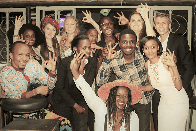 Winners are grinners: Rotaract members, showing the Vijana Poa hand signal, celebrate a good night of fundraising to help youth unemployment at their 60s-themed bash..