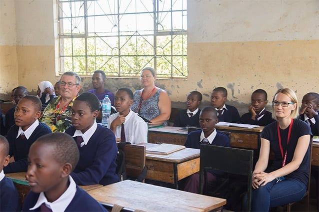 Bringing it home: Wens (pictured back, left) accompanies visitors to local government schools.