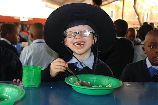 Sebastian's all smiles: Enjoying his favourite school meal, pilau (spicy rice and meat).