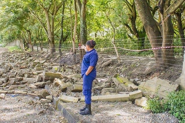 Starting from scratch: A guard at Smith Secondary Campus assesses flooding damage. 