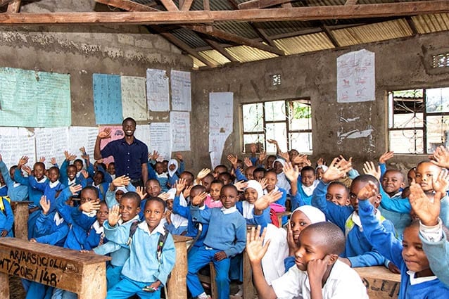 A trip down memory lane: Godwin visits his old primary school and the students are more than happy to capture the moment with him.