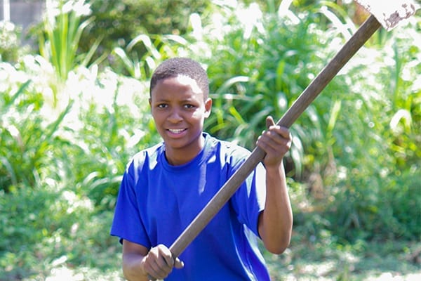 Reap what you sow: Form 4 student Quinn helps to harvest the produce.