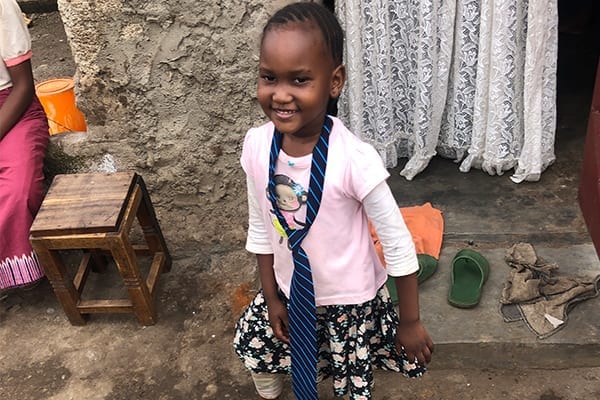 Biggest Supporter: Daudi's younger sister, Lydia, trying on his St Jude's tie. 