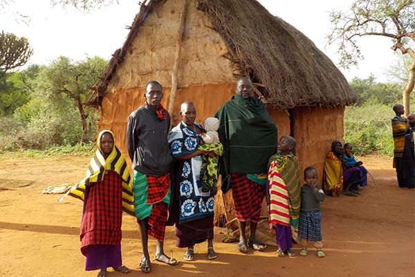 Community Leader: William with his family outside their Maasai boma where they live in the Manyara region.