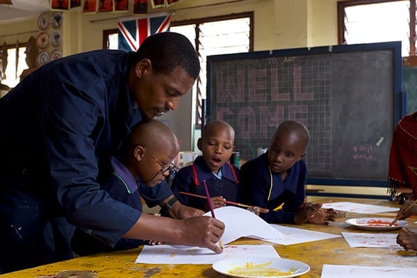 Watch and learn: Mr Kephas showing observant students how to use a paint brush.